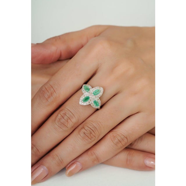 Crafted in 925 sterling silver, this elegant floral cocktail ring features four marquise-cut emeralds arranged in a...