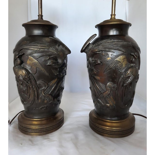 Bring timeless elegance and artistic craftsmanship to your space with this striking pair of antique Japanese bronze table...