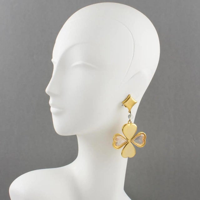 These gorgeous Kenzo Paris clip-on earrings feature a long dangling drop shape with a four-leaf clover design and heart-...