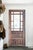 This artisan-made glass-pane entry French door features beautifully hand-carved panels paired with classic divided-light...