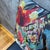 Dense tropical foliage and large exotic birds fill every corner of the cover against a dark, near-black ground. A crimson...
