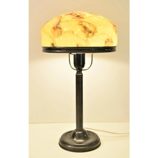 A very simply designed swedish grace/art deco table lamp, made of hand blown glass and bronze patinated brass. The lamp...