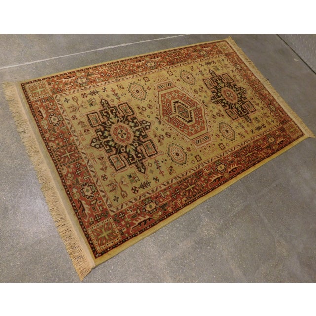 Three geometric medallions on yellow gold background, within rust border. Machine made. Hand finished. 3'3"x 5'2"