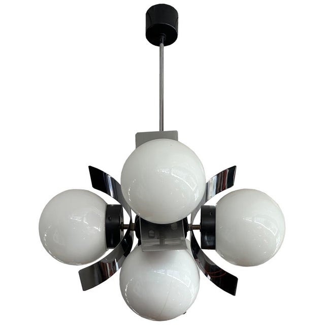 Striking retro pendant lamp from the 1970s, featuring a combination of curved chrome arms and four pressed glass shades....