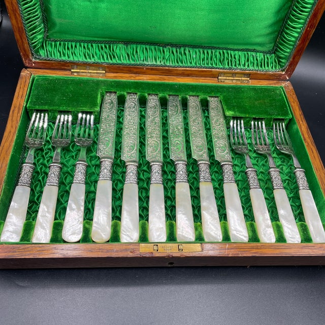 Set in a fitted oak box, awaiting a monogram, this chic fruit/dessert set has mother of pearl handles and silverplate...