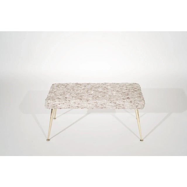A petite bench featuring hand-polished tapered brass legs, original from Italy, circa 1950-1959. Newly upholstered in...