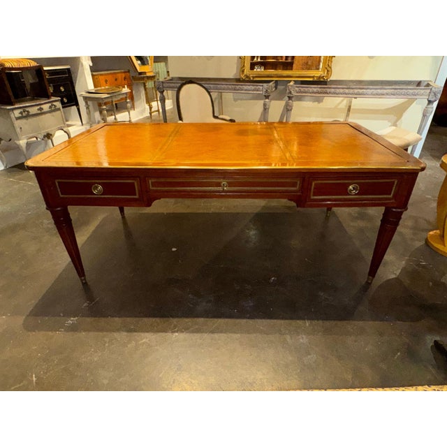 This product is a large 19th-century French Louis XVI walnut bureau plat. This elegant desk features intricate detailing...
