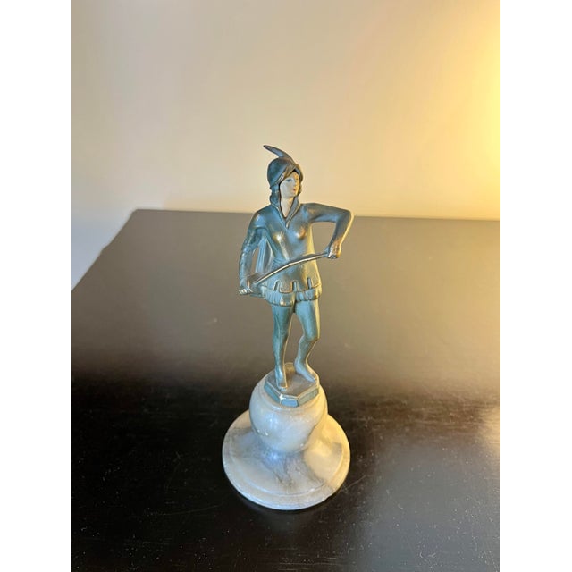 Lovely French Art Deco piece depicting a figure wearing a tunic, hood, and holding a bowed sword. Sits atop a variegated...