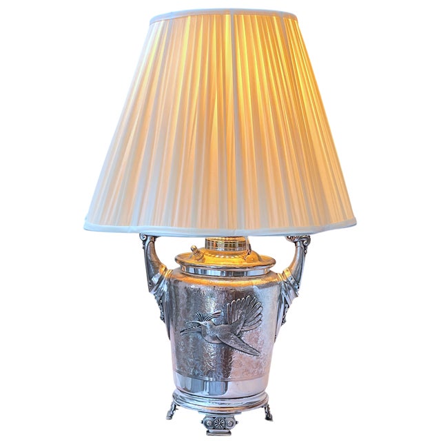 A striking antique silver-plated oil lamp, later professionally converted for use as an electric table lamp. The...