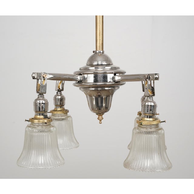 This fixture features a tall support stem with a mixed brass and nickel finish. The four radiating arms are fitted with...