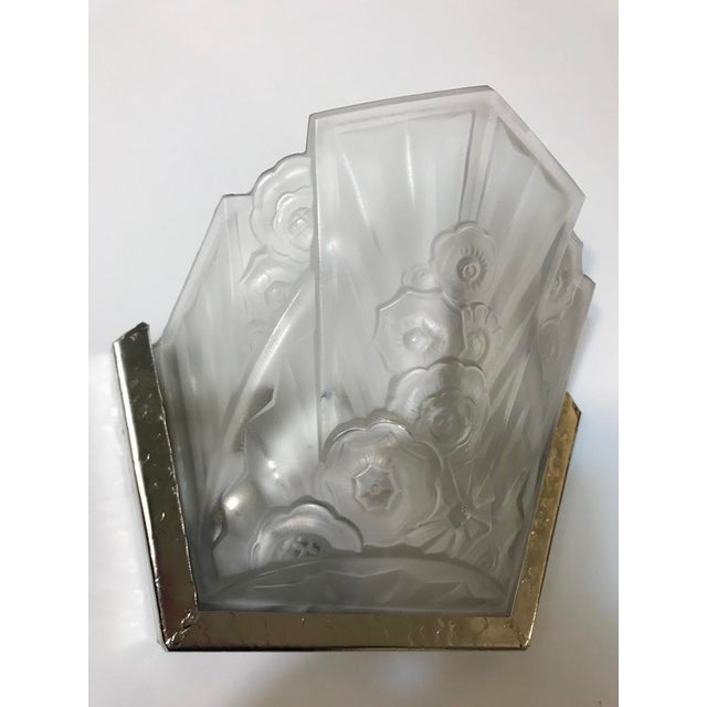 A pair of French Art Deco wall sconces signed by the French artist "J Robert" in clear frosted glass shades with geometric...