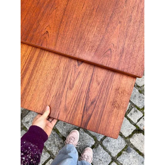 This extendable teak dining table combines elegance and functionality in the finest Scandinavian tradition. The tabletop...