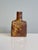 This small, handcrafted, free-form ceramic vase, in warm earth tones and featuring a play of matte and glossy glaze, was...