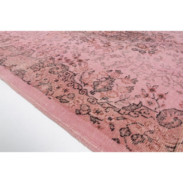 This is a vintage Turkish Oushak rug from the Mid 20th Century. The piece was hand-knotted.