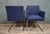 Pair of modern armchairs with clean lines, resting on a chromed tubular metal frame with a sled base. The wide,...