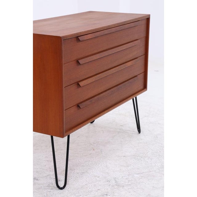 Vintage teak chest of drawers from WK Möbel with four spacious drawers and striking, long handles. The compact body rests...