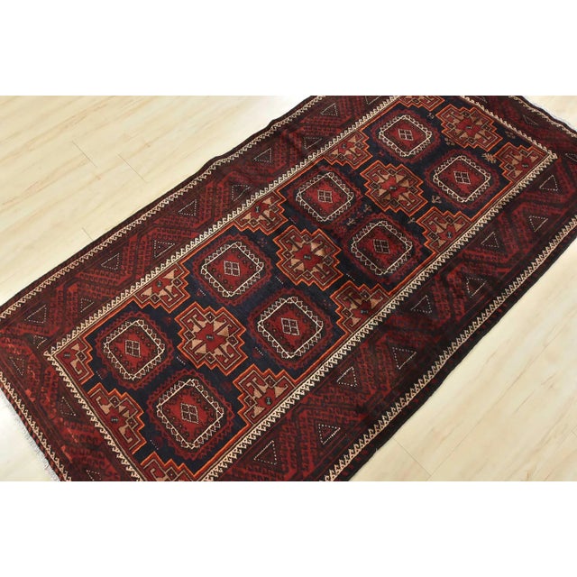 An authentic vintage tribal Baloch rug hand-knotted with fine wool and natural dyes. This nomadic oriental rug features...