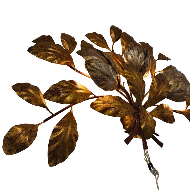 Elegant wall light made of golden brass with finely modeled leaves grouped in bouquets. Its fan shape gives great elegance...