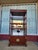 Sturdy wood display hutch has a dark reddish-brown finish. The upper section features two glass-inlay shelves and a...