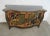 Chinoiserie style credenza, black lacquered finish with Asian Scenes , floral gold gilt accents . 2 doors with 2 drawer...