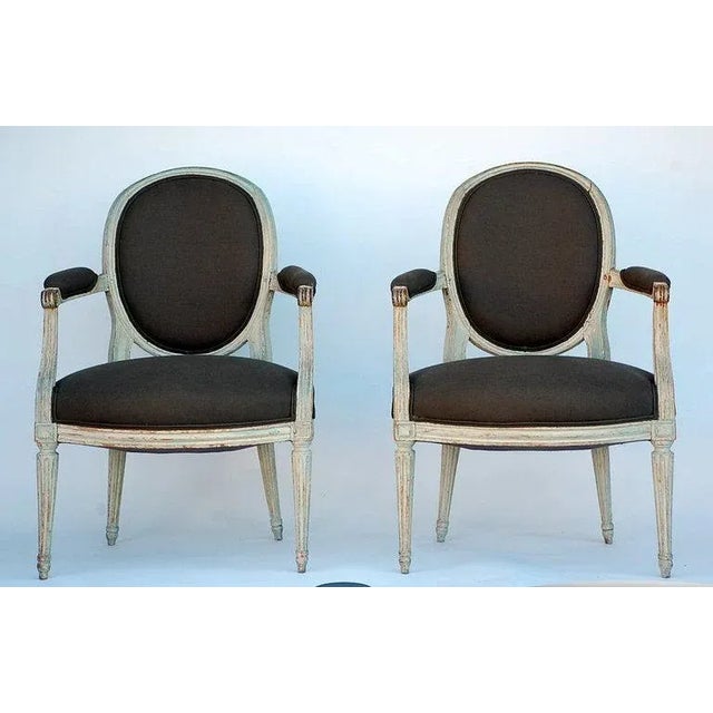 Pair of period Louis XVI whitewashed "medaillon" armchairs. Restored and reupholstered in dark grey linen.