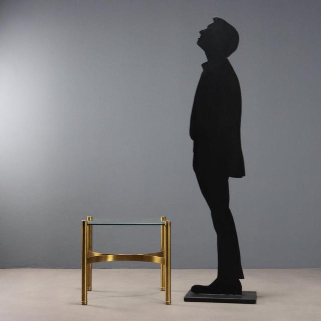 Italian-made coffee table from the 1970s, with a brass frame and glass top. The glass top, despite showing small chips,...
