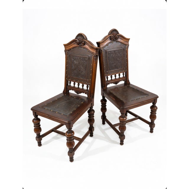 A striking and authentic pair of vintage dining chairs in the desirable Jacobean / Spanish / Henry II Revival style, circa...