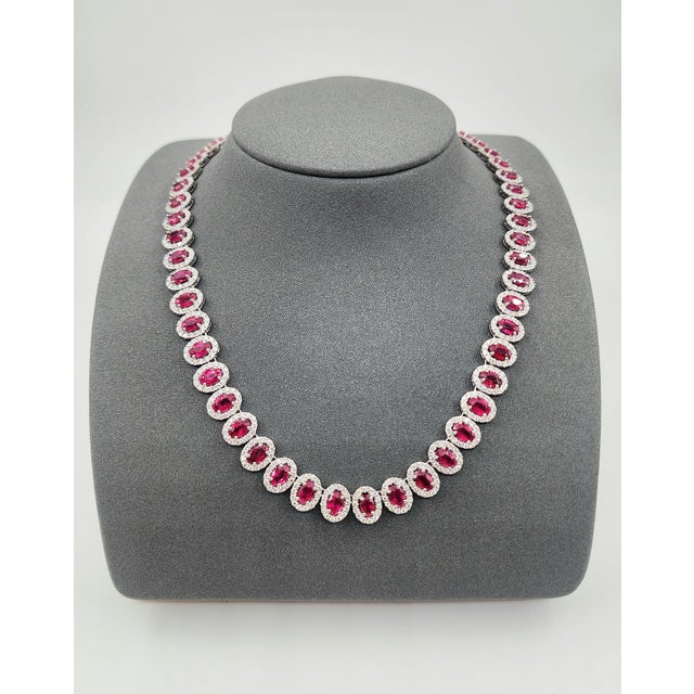 This stunning necklace showcases a series of 54 oval-cut rubies, totaling 30.20 carats, set in luxurious platinum. Each...