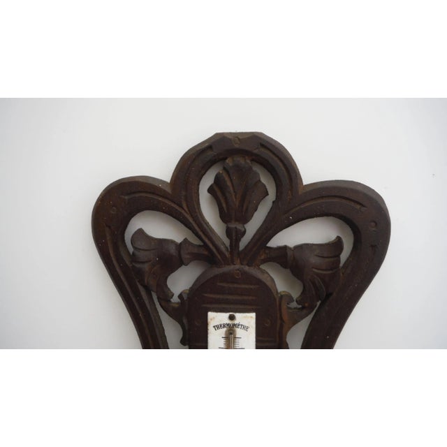 French Black Forest-style wood barometer with cutout flower design, circa 1900.