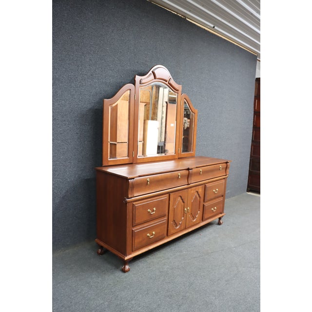 Crafted by Dutch Designs of Ohio, this substantial cherry dresser and matching tri-fold mirror embody classic American...