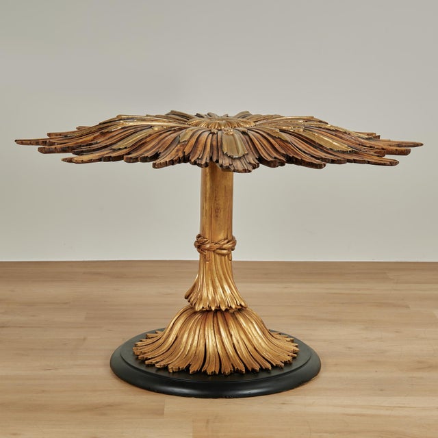 Exceptional Italian mid century table with a carved organic floral motif, handcrafted in walnut having a parcel gilt top...