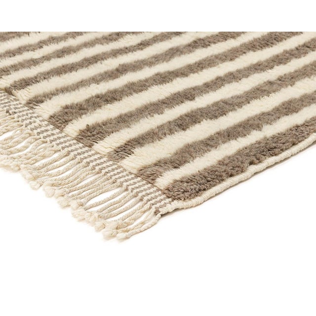 Timeless stripes, effortlessly versatile. This hand-knotted Moroccan wool rug features clean, alternating vertical stripes...