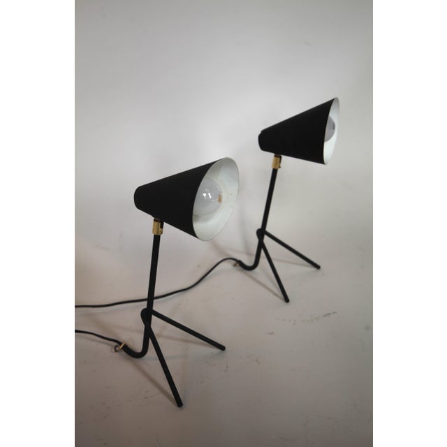 Pair of Swedish tripod lamps produced during the 1950s. Executed in black enamelled metal with brass details. The...