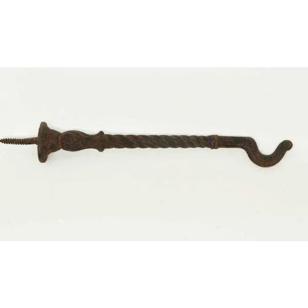 Rusted black cast iron twisted Victorian plant hook.