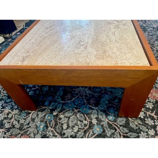 Beautiful vintage mid-century coffee table featuring a genuine travertine stone top set in a warm wood waterfall frame....