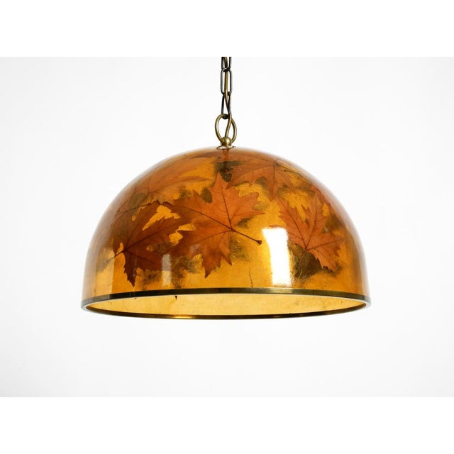 A beautiful, rare, and large italian pendant lamp from the 1970s, made of resin with embedded maple leaves. stunning,...