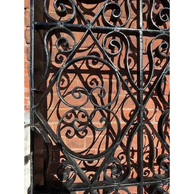 Truly impressive set of late 20th Century monumental black wrought iron driveway gates having an exuberant scrollwork and...