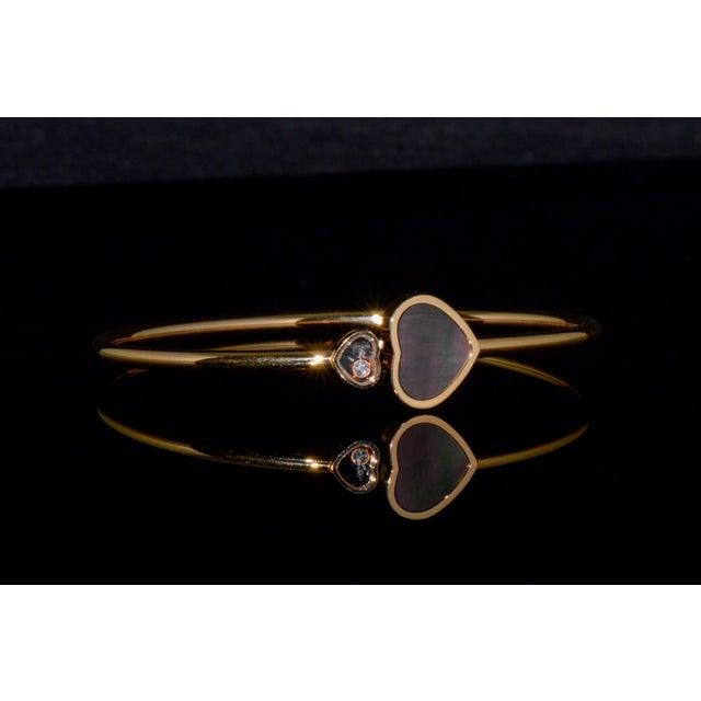 Authentic Chopard Happy Hearts bangle beautifully handcrafted in solid 18K rose gold. This iconic design pairs an...