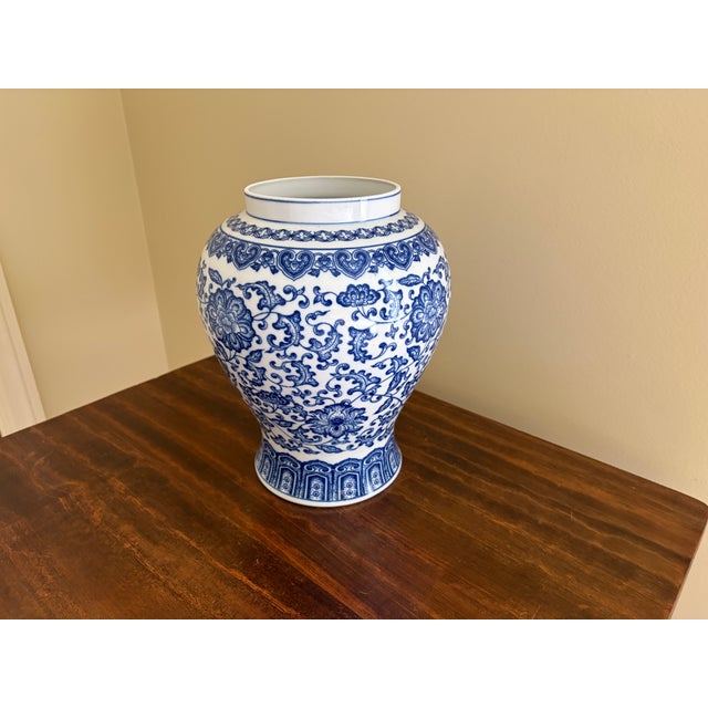 A classic blue and white ginger jar form vase, decorated throughout with delicate Chinoiserie floral motifs. The pattern...