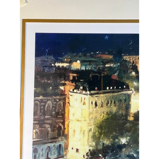 A framed limited edition print by Michael Logan, showing the Arc de Triomphe in Paris at night. The scene highlights...