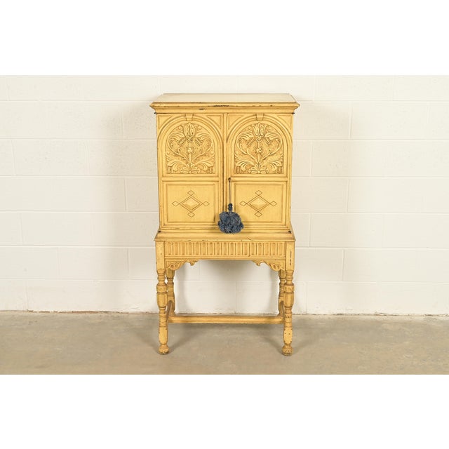 A gorgeous English Jacobean or Tudor style lift top bar or liquor cabinet By Berkey & Gay USA, Circa 1920s Ornate carved...