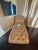 Professionally maintained chaise used as decor in guest bedroom, legs are wooden with gold detail.