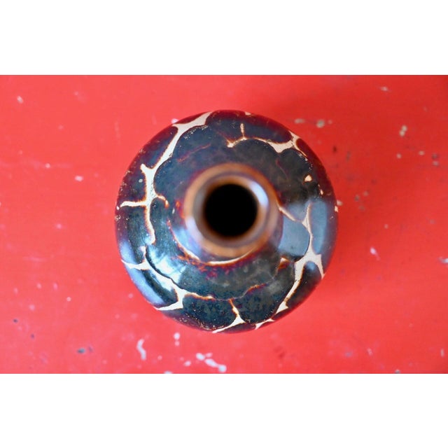 Bottle-shaped, with its perfectly rounded, globular body and long, slender neck, this small vase possesses that slightly...