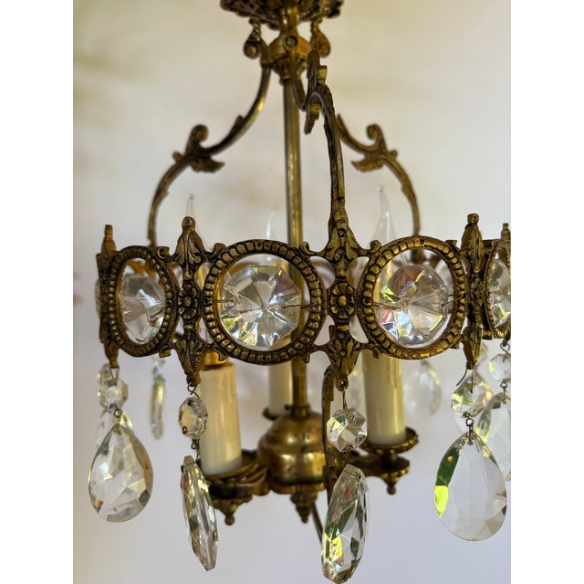 This light is a vintage cage-style chandelier, dating from the 1950's. It's design is characterizered by a central brass...