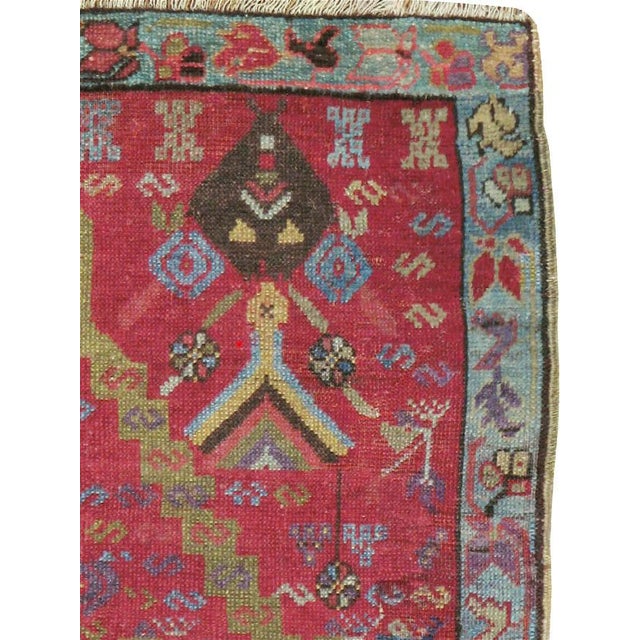 This early 20th century Turkish Ghourdes rug, measuring 3' 0" x 4' 8", presents a bold directional prayer design centered...