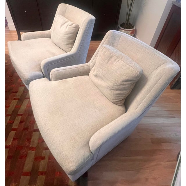 Elegant pair of upholstered armchairs in a neutral cream fabric. these chairs are designed by Barbara Bary for Baker and...
