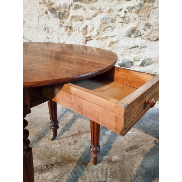 A charming French round table dating from the 1920s, crafted from beautiful solid walnut. This elegant piece stands on...