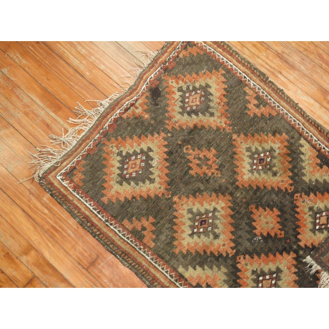A tribal balouch rug from the early 20th century in brown and orange accents, circa 1930 Measures: 2'6” x 3'10”.
