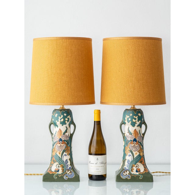 A pair of rare hand-painted faience table lamps built on twin-handled "ear" vases from the Arnhemsche Fayencefabriek. Both...