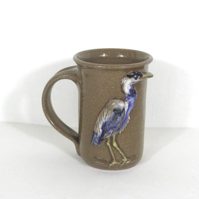Vintage studio pottery stoneware mug with a bird. This is brown with a raised great blue heron on the side. Very well done...
